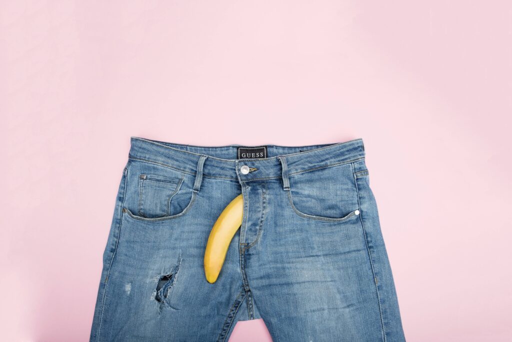 Eine Banane ragt aus dem Reißverschluss einer Jeans. Bei fortgeschrittener Erkrankung tritt häufig eine erektile Dysfunktion auf.