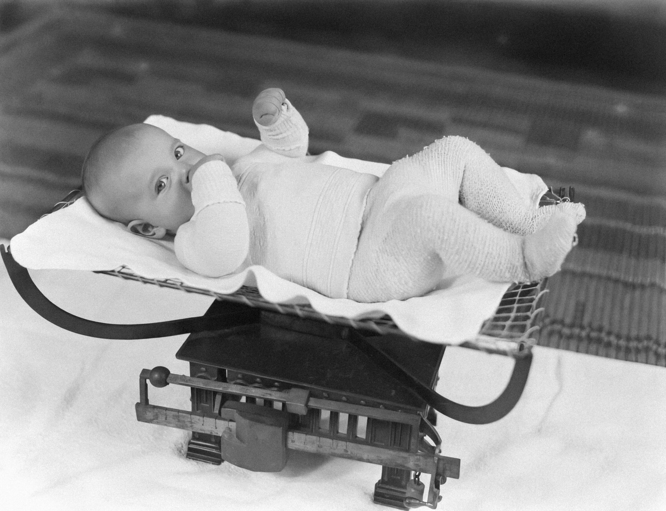 Ein Baby liegt auf einer Waage und wird gewogen. Die genaue Dosierung von Schmerzmitteln bei Kindern muss zwingend nach dem Körpergewicht erfolgen, nicht nach dem Alter.